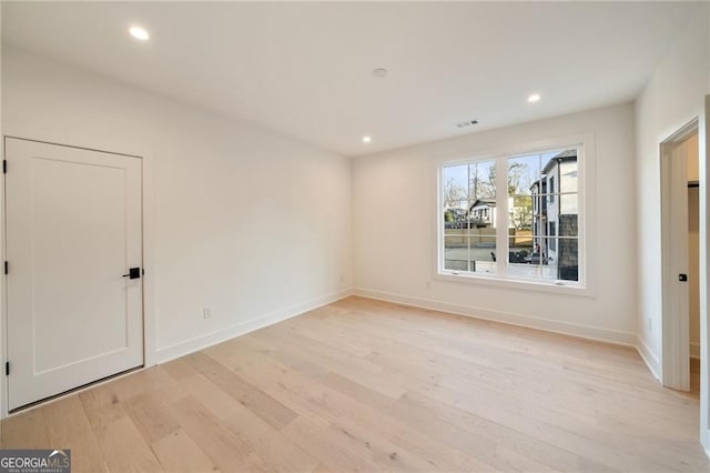 unfurnished room with recessed lighting, baseboards, and light wood finished floors