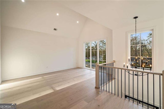 interior space with a wealth of natural light, visible vents, baseboards, and wood finished floors