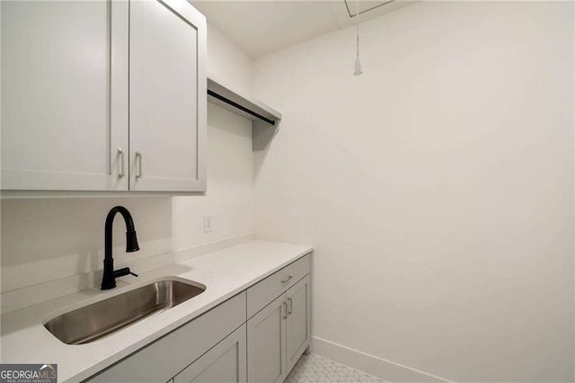 interior space with a sink, baseboards, and light countertops