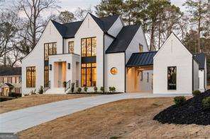 view of front of property featuring a standing seam roof, concrete driveway, and metal roof