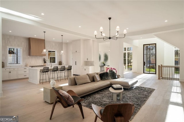 living area featuring light wood finished floors, a notable chandelier, and recessed lighting