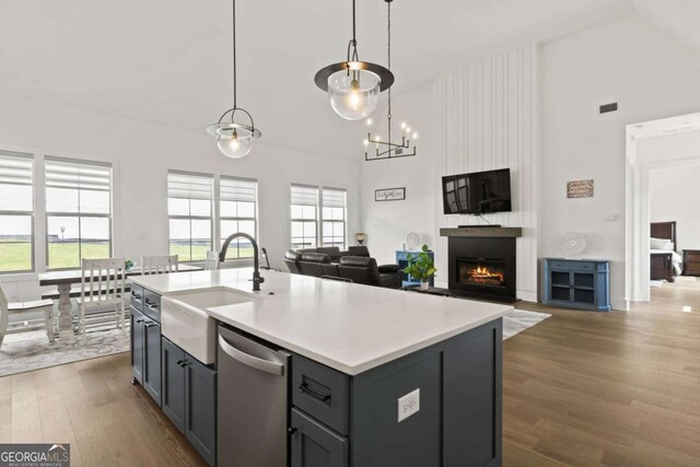 kitchen featuring a sink, stainless steel dishwasher, open floor plan, and a fireplace