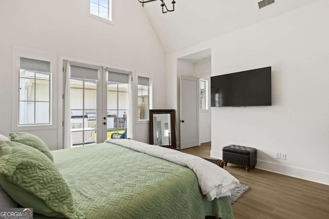bedroom with access to exterior, wood finished floors, visible vents, and baseboards