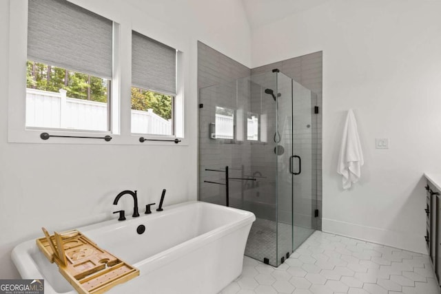 full bath featuring baseboards, a soaking tub, lofted ceiling, a stall shower, and tile patterned flooring