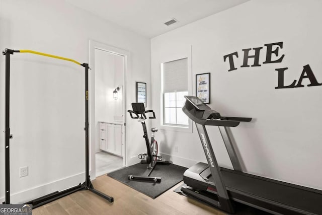 workout room with visible vents, baseboards, and wood finished floors