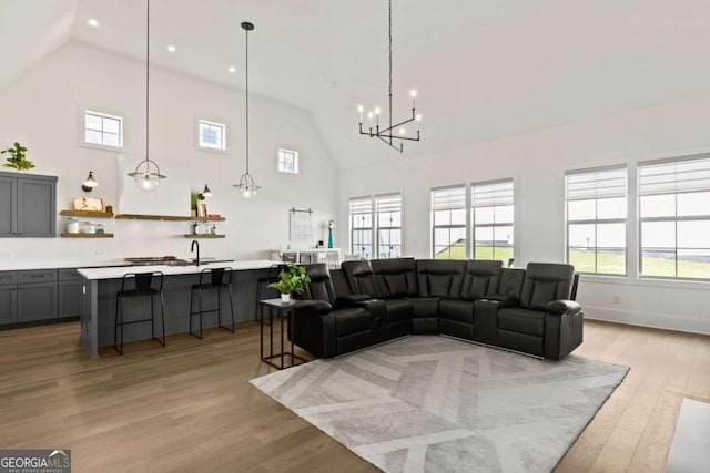 living area featuring recessed lighting, light wood-style floors, baseboards, and high vaulted ceiling
