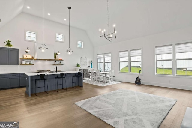 interior space with recessed lighting, baseboards, high vaulted ceiling, and light wood-style flooring