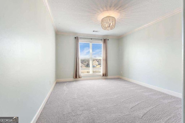 spare room featuring visible vents, baseboards, ornamental molding, carpet floors, and a textured ceiling