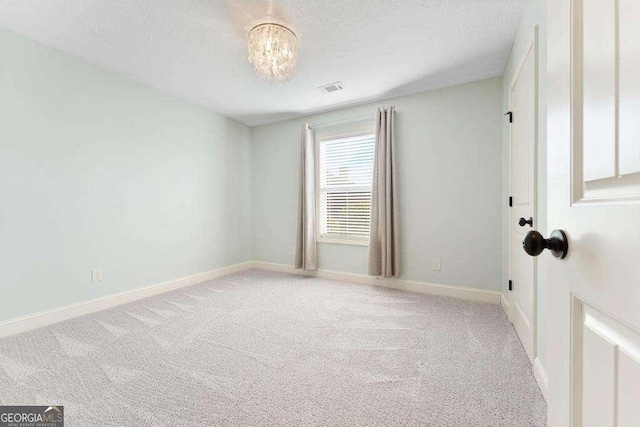 unfurnished room with visible vents, carpet, and baseboards