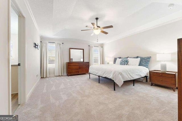 bedroom with crown molding, baseboards, carpet, a textured ceiling, and a raised ceiling