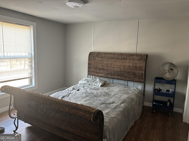 bedroom with baseboards and wood finished floors