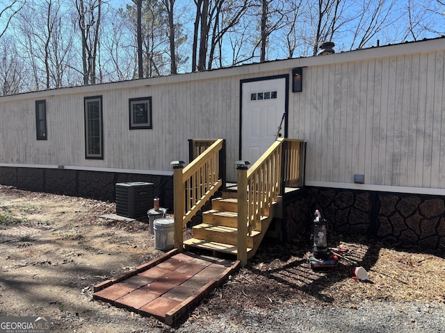 view of exterior entry featuring crawl space and central air condition unit