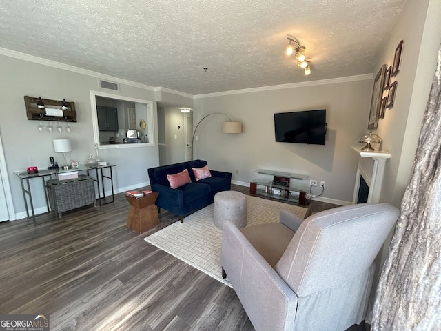 living room featuring visible vents, a textured ceiling, wood finished floors, and ornamental molding