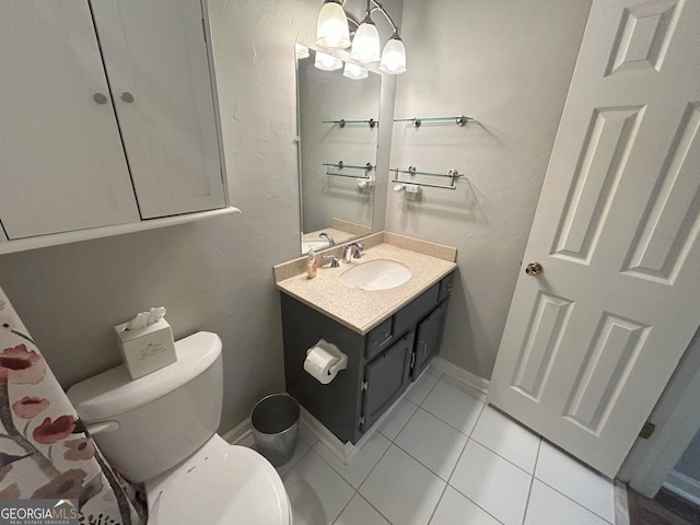 bathroom featuring tile patterned floors, toilet, vanity, and baseboards