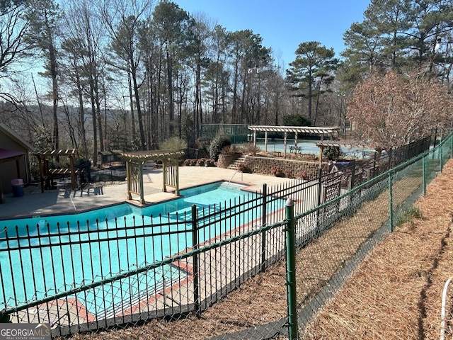 community pool with a patio area, a pergola, and fence