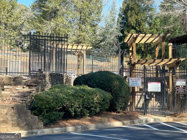 view of gate featuring fence and a pergola