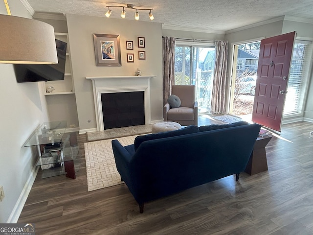 living room featuring dark wood-style floors, a textured ceiling, and ornamental molding