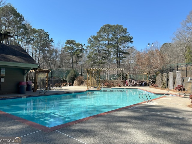 community pool with a patio, fence, and a pergola