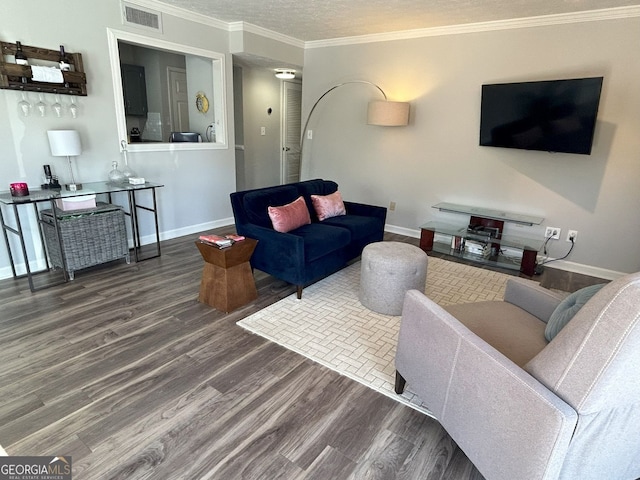 living area with wood finished floors, visible vents, baseboards, a textured ceiling, and crown molding