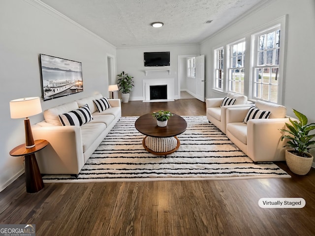 living room with wood finished floors, a textured ceiling, and ornamental molding