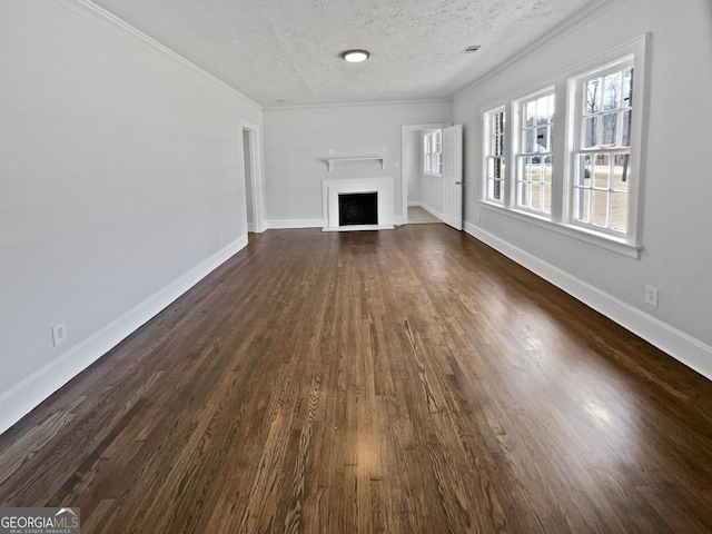 unfurnished living room with crown molding, baseboards, dark wood-type flooring, and a textured ceiling