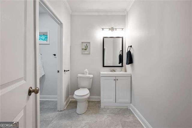 bathroom featuring baseboards, vanity, crown molding, and toilet