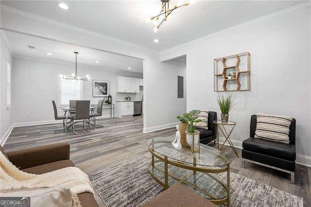 living area featuring an inviting chandelier, wood finished floors, crown molding, and baseboards