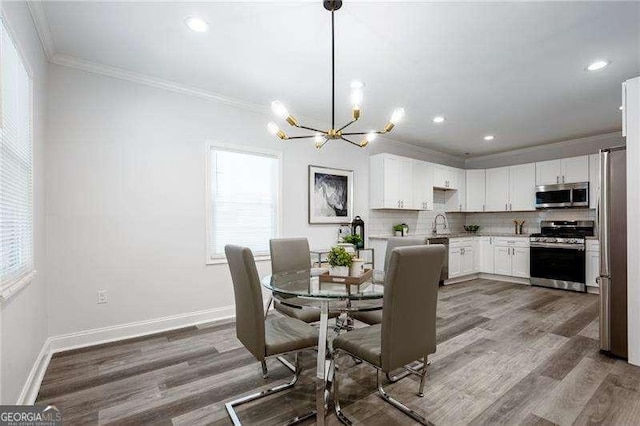 dining space with plenty of natural light, crown molding, baseboards, and wood finished floors