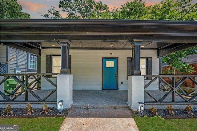 exterior entry at dusk featuring covered porch