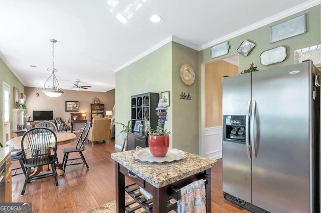 kitchen featuring ceiling fan, crown molding, wood finished floors, and stainless steel fridge