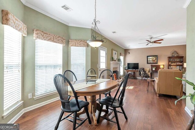 dining room featuring hardwood / wood-style floors, a ceiling fan, visible vents, and ornamental molding