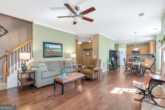 living room featuring wood finished floors, a ceiling fan, stairs, and ornamental molding