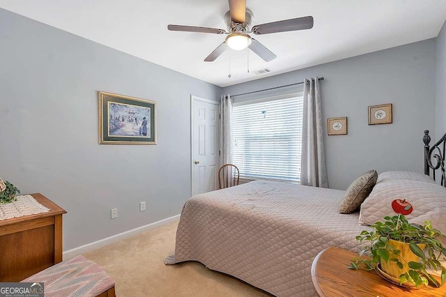 bedroom featuring baseboards, visible vents, light colored carpet, and ceiling fan