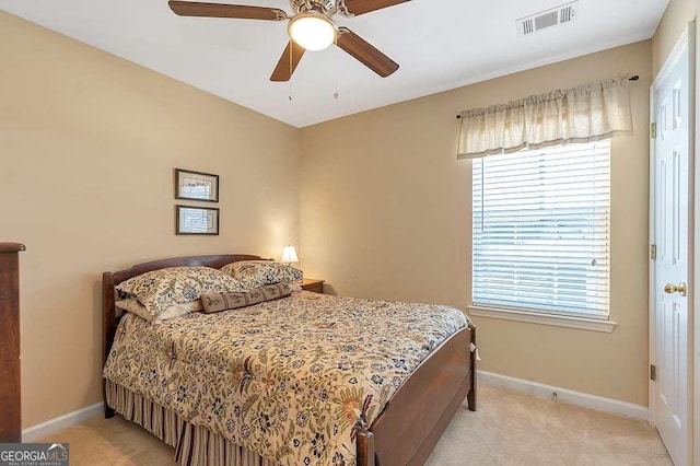 bedroom featuring multiple windows, visible vents, and light carpet