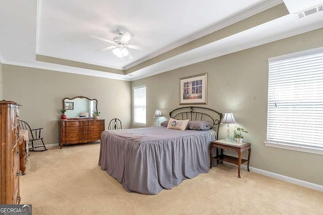 bedroom featuring a tray ceiling, visible vents, ornamental molding, baseboards, and light colored carpet