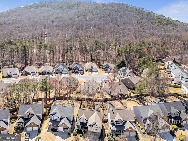 birds eye view of property featuring a mountain view, a view of trees, and a residential view