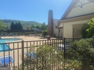 exterior space featuring a community pool and fence