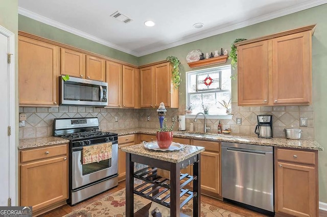kitchen with light wood finished floors, visible vents, appliances with stainless steel finishes, and a sink