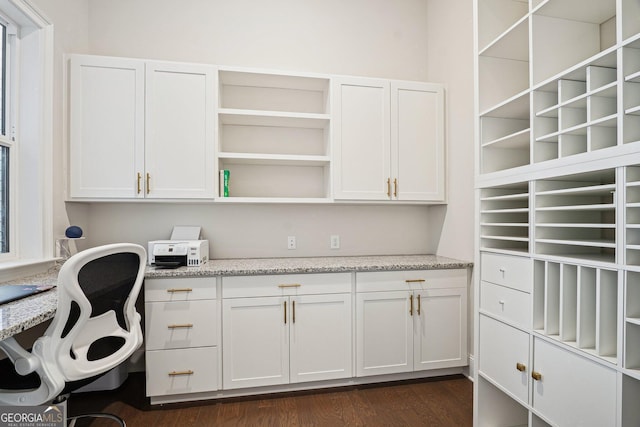 office space featuring built in study area and dark wood-type flooring