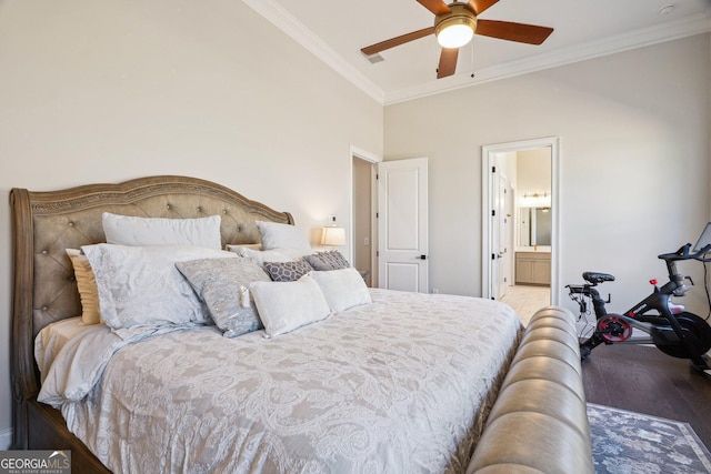 bedroom featuring a ceiling fan, ensuite bath, wood finished floors, and ornamental molding