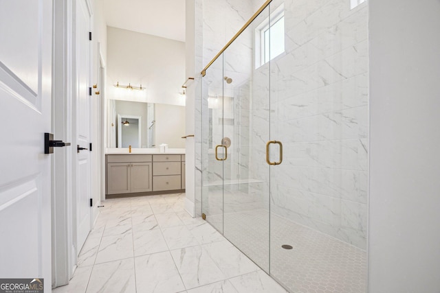 bathroom with marble finish floor, vanity, and a shower stall