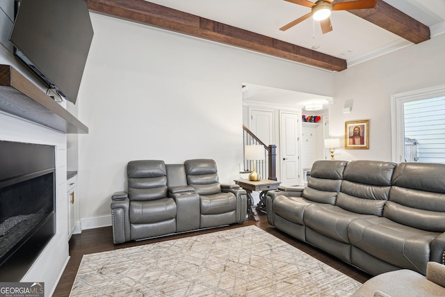 living room with beamed ceiling, a ceiling fan, dark wood-style floors, a fireplace, and stairs