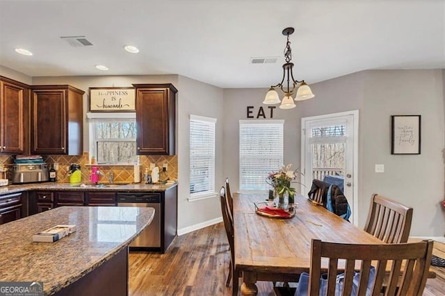 kitchen featuring stainless steel dishwasher, dark wood-style floors, visible vents, and backsplash