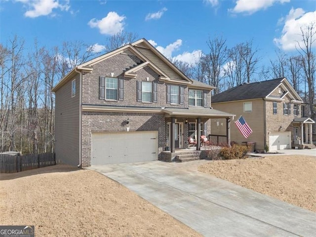 craftsman-style house with a garage, brick siding, covered porch, and driveway