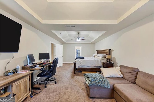 bedroom with visible vents, a raised ceiling, light colored carpet, and ceiling fan