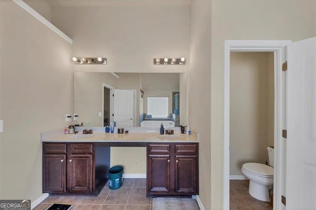 bathroom featuring double vanity, toilet, tile patterned floors, and a sink