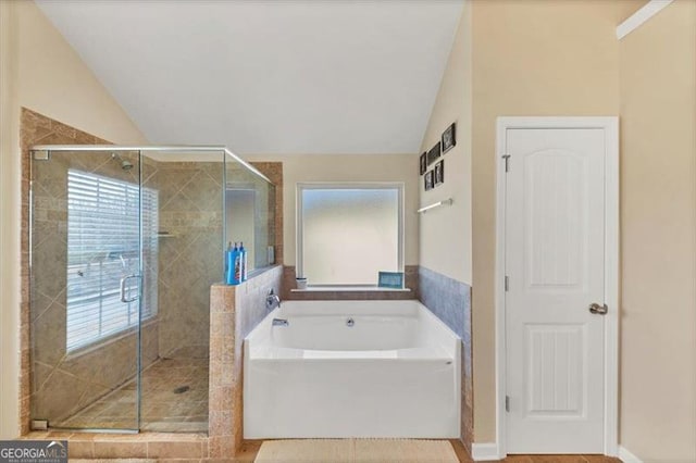 full bath featuring a shower stall, a bath, a healthy amount of sunlight, and lofted ceiling