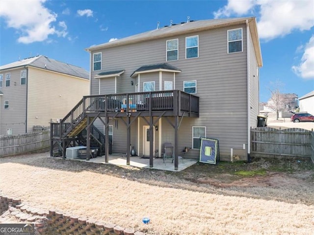 back of property featuring stairway, a wooden deck, a patio, and fence