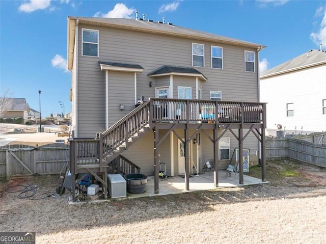 rear view of property featuring stairway, a patio, a deck, and fence