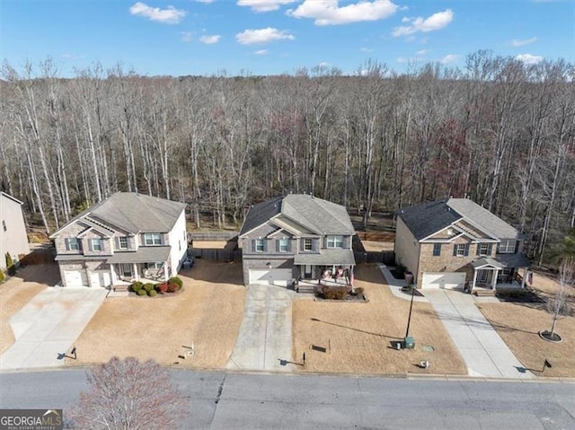 drone / aerial view featuring a wooded view